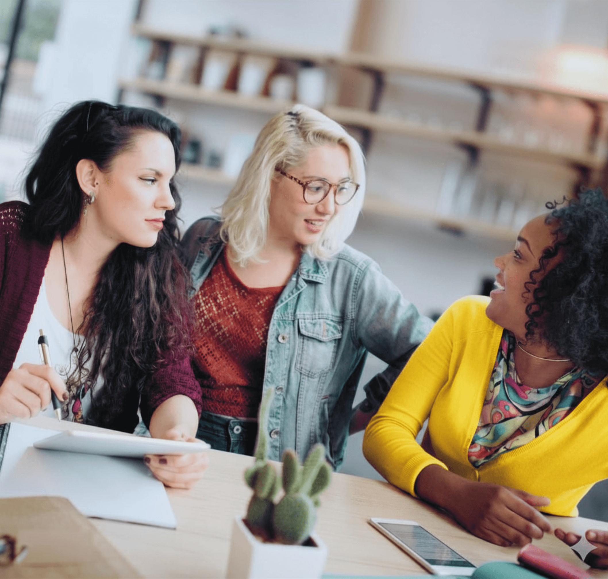 Three women at a coffee shop collaborating